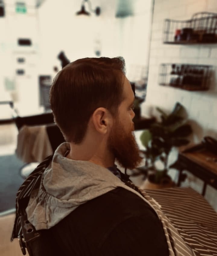 Client with a sharp fade and full beard